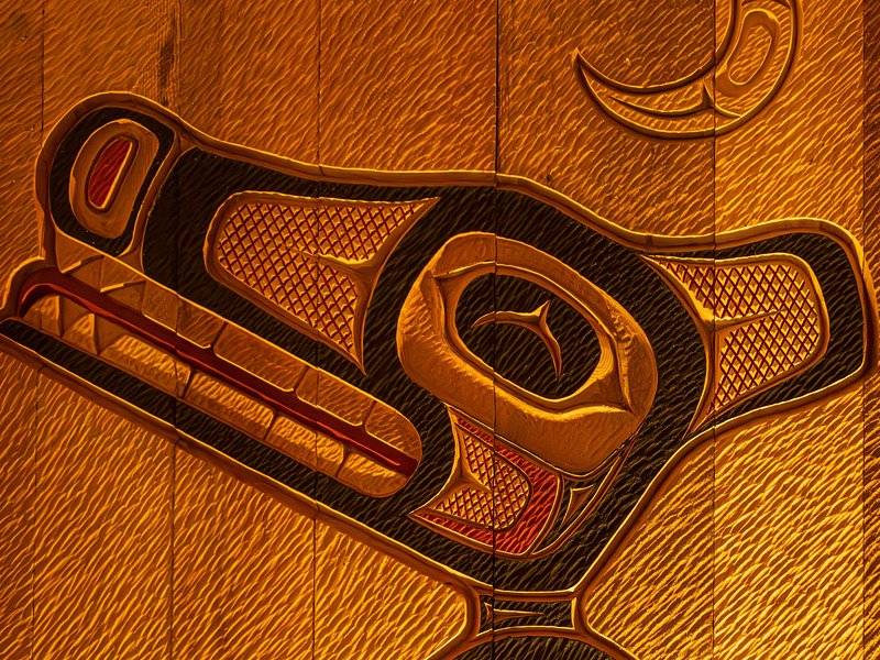 Detail of a red and black formline carving in wood