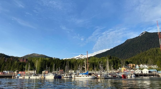 Sailboats and fishing boats in a Ketchikan harbour, forested mountains behind